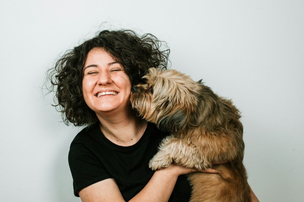 Smiling woman hugging her emotional support dog at home