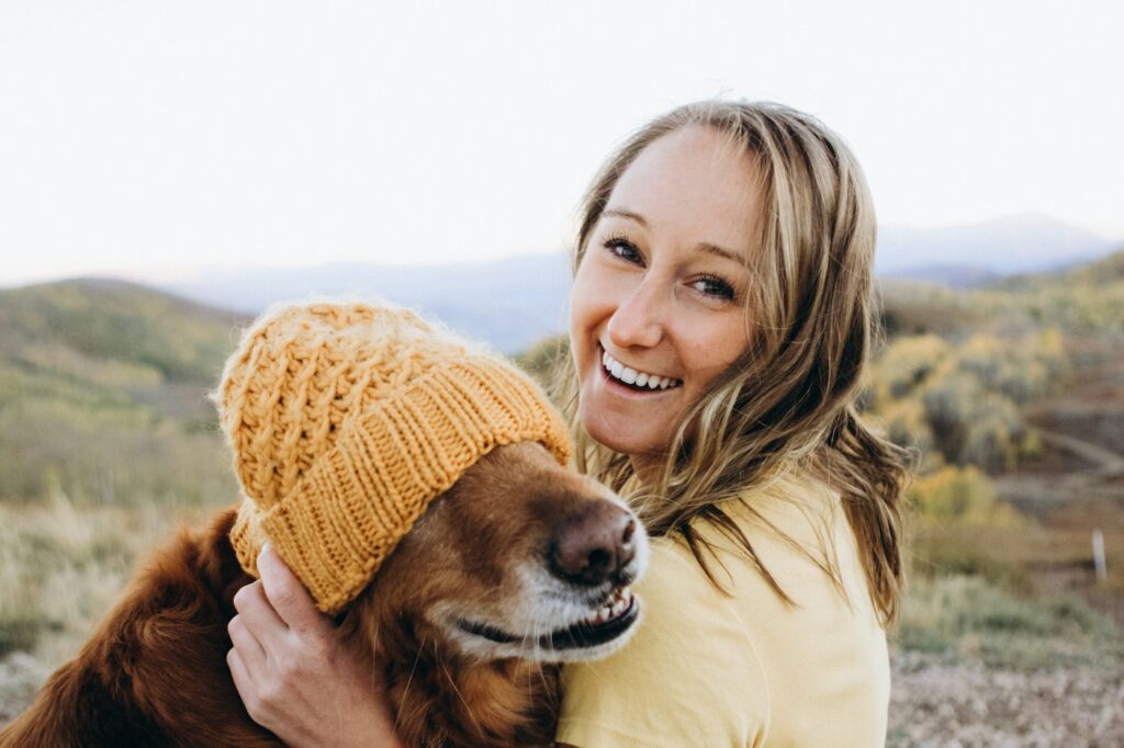 Smiling woman hugging her dog outdoors