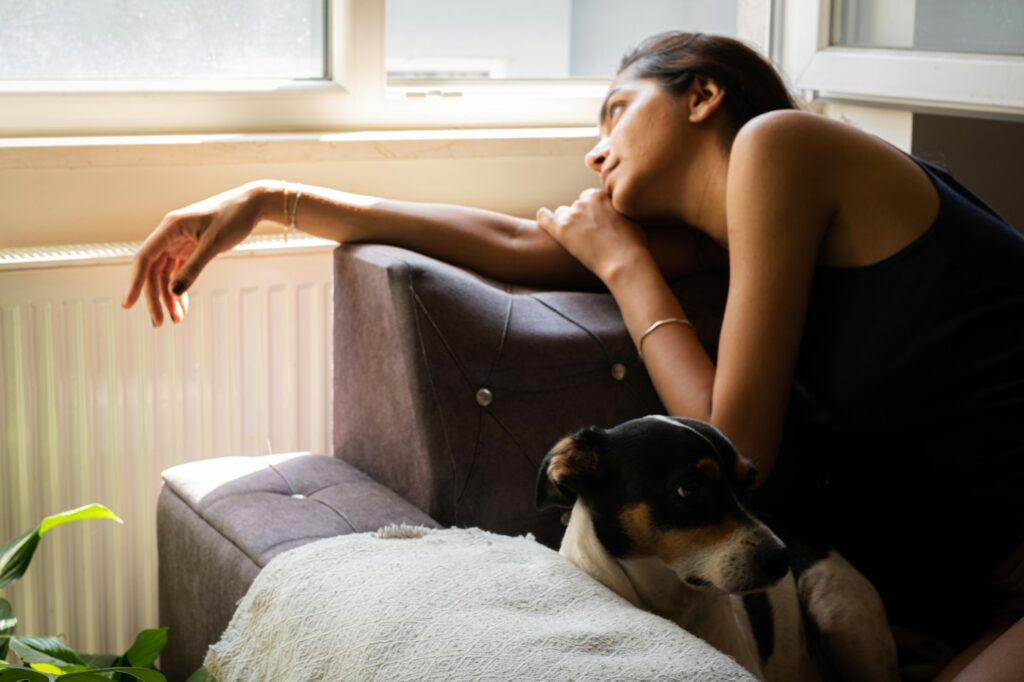 Woman sitting on a couch with her dog
