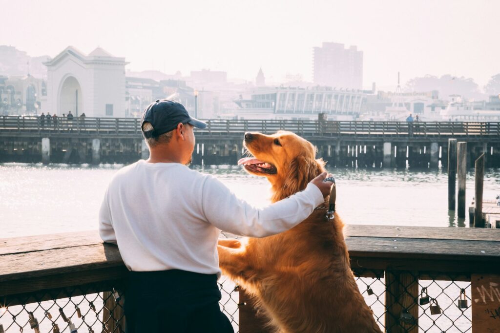 Man standing outdoors beside his Labrador retriever